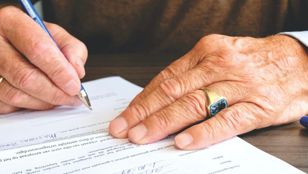 A stock image of someone signing a document, representing someone signing one of the three main types of contract under employment law in the Dominican Republic